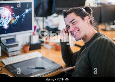 Portrait smiling, confident male graphic designer working at desk Stock Photo