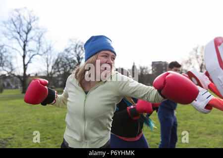 Determined senior woman boxing in park Stock Photo