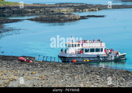 Tour boat using a floating pontoon to access Lunga, Treshnish Isles, Scotland. There is no permanent dock or slipway on the island. Stock Photo