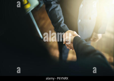 Business handshake and business people.Vintage tone Retro filter effect,soft focus,low light. handshake in office. success concept. Stock Photo
