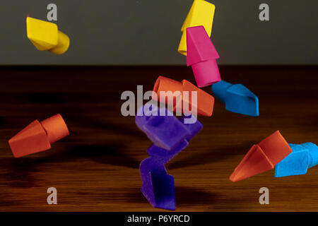 Pencil erasers caught in mid fall cascading onto a wooden  desktop Stock Photo