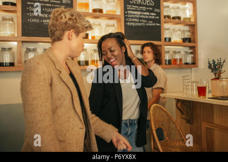 Two laughing girlfriends dancing together in a bar Stock Photo