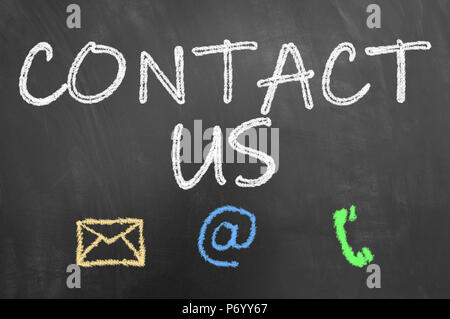 Contact us chalk text on blackboard or chalkboard as customer support service and public relation concept Stock Photo