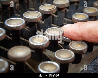 Closeup finger typing on vintage typewriter covered with dust Stock Photo