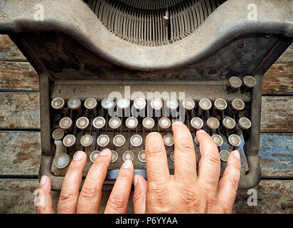 Top view woman typing on vintage typewriter covered with dust Stock Photo