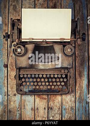 Vintage Typewriter covered with dust on wooden desk topview Stock Photo