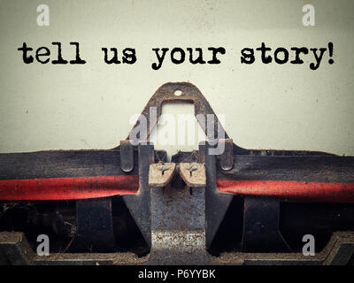 Close up of old typewriter covered with dust with tell us your story text Stock Photo