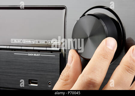 Closeup male hand turning blank knob of amplifier Stock Photo