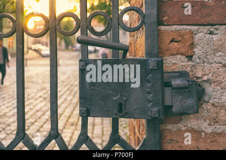 Large iron lock with a handle on the iron door to the street Stock Photo