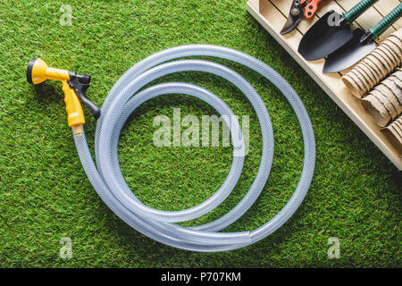 top view of hosepipe and gardening equipment on planks Stock Photo