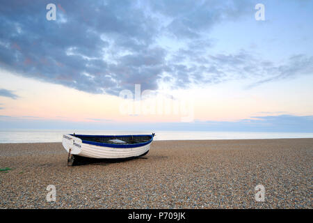 England, Suffolk, Aldeburgh. One boat on the shingle beach at dusk. Stock Photo