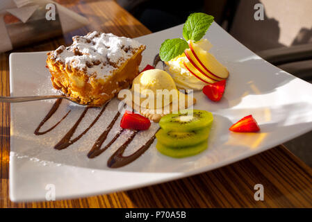 Polish style apple pie with ice cream fruit and chocolate swirl. Stock Photo