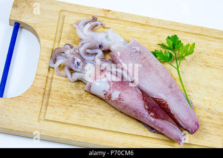 Fresh raw squids in white background / cuttlefish or squid ,fresh squid on Chopping wood / fresh squid's & cuttlefish on a cutting board in white back Stock Photo