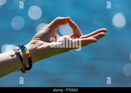 A yoga instructor demonstrates yoga poses during an outdoor yoga session in nature with blue skies and brilliant colours. Stock Photo