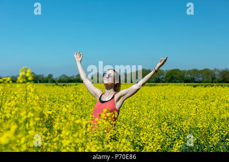 A yoga instructor demonstrates yoga poses during an outdoor yoga session in nature with blue skies and brilliant colours. Stock Photo