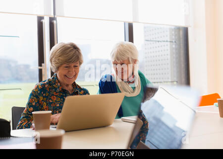 Senior businesswomen using laptop in meeting Stock Photo