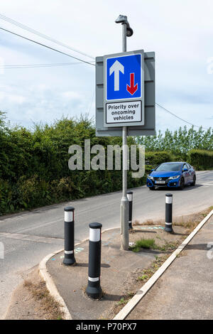 Car approaching a 'Priority over oncoming vehicles' sign in Blackpool, Lancashire Stock Photo