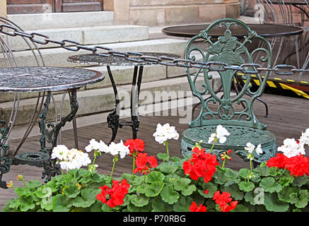 Table, chair and geranium flowers in cafe in Stokholm, Sweden Stock Photo