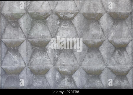 Concrete fence with geometric relief. Grey abstract grunge aged background Stock Photo
