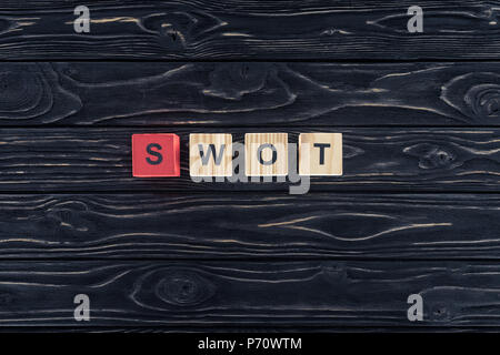 top view of word swot made of wooden blocks on dark wooden tabletop Stock Photo