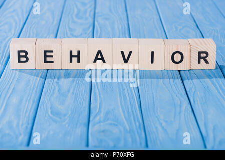 close up view of behavior word made of wooden blocks on blue tabletop Stock Photo