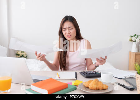 Asian woman freelancer upset with work problem with laptop on mess table.work at home concept.stress working Stock Photo
