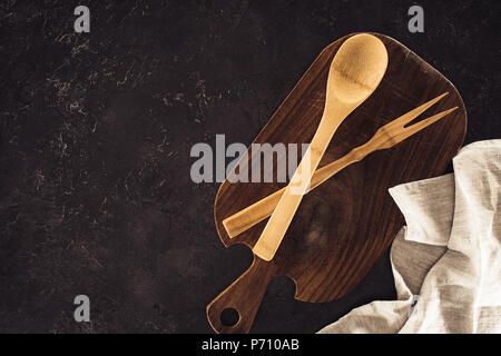 top view of spoon, fork for meat on wooden cutting board and sackcloth on marble table Stock Photo