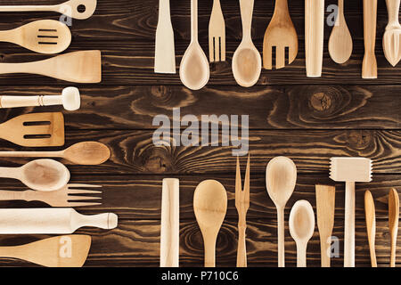 elevated view of kitchen utensils placed in three rows on wooden table Stock Photo