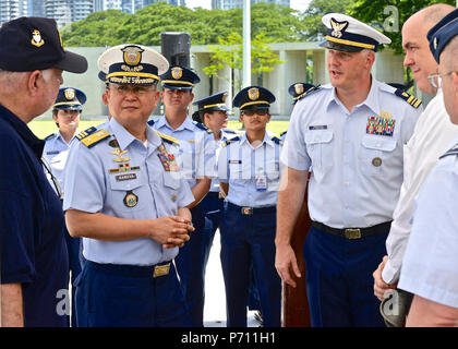 Officer-in-Charge Commodore Joel Garcia, Philippine coast guard, Lt. Cmdr, Jeremy Obenchain ,U.S. Coast Guard, maritime advisor Defense Threat Reduction Agency and U.S. Embassy, and Chief Petty Officer John O’Neil, U.S. Coast Guard Combat Veterans Association,  discuss the life of Lt. James Crotty at the Military American Cemetery, May 9, 2017. The ceremony was culminated with the reveal of  Lt. Crotty’s name now etched on the U.S. Coast Guard wall in the cemetery. Stock Photo