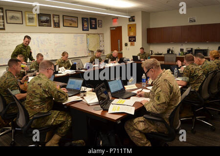 U.S. Army Reserve Maj. Geoff Tibbetts and Sgt. 1st Class Malcolm Flanders conduct planning with students at the U.S. Marine Corps’ School of Advanced Warfighting at Quantico Marine Corps Base, VA, May 9, 2017, as part of Operation Deep Harbor. Civil affairs planners assigned to the 352nd Civil Affairs Command, Tibbetts and Flanders embedded with the students for Deep Harbor, the final planning exercise in the course. Stock Photo