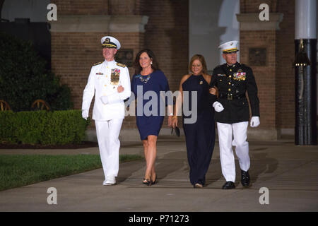 U.S. Navy Vice Adm. Walter E. Carter Jr., far left, superintendent, U.S. Naval Academy, and U.S. Marine Corps Lt. Gen. Robert S. Walsh, far right, commanding general, Marine Corps Combat Development Command, and deputy commandant, Combat Development and Integration, walk down center walk with their wives during an evening parade at Marine Barracks Washington, Washington, D.C., Aug. 18, 2017. Evening parades are held as a means of honoring senior officials, distinguished citizens and supporters of the Marine Corps. Stock Photo