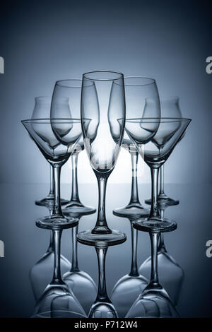 silhouettes of different empty champagne, martini and wine glasses with reflections, on grey Stock Photo