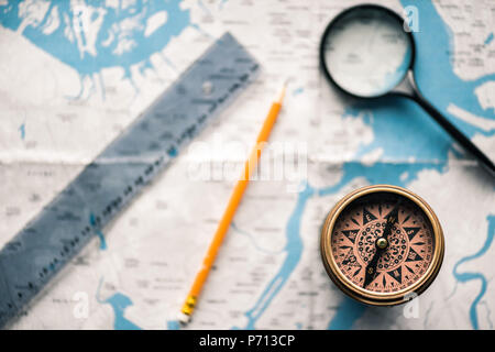top view of vintage compass with ruler and magnifying glass on map Stock Photo