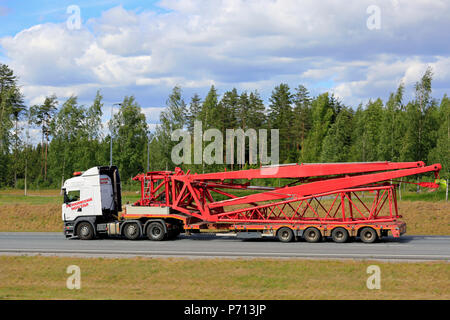 Semi truck transports lattice extension for large Liebherr mobile crane of Pekkaniska on trailer on motorway, side view. Salo, Finland - June 8, 2018. Stock Photo