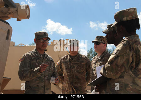 Sgt. 1st Class Joel Vallete, signal section chief of Headquarters Company, 1st Battalion, 8th Infantry Regiment, 3rd Armored Brigade Combat Team, 4th Infantry Division, goes over the safety features on a M113 Command Post Vehicle with a few of his soldiers on May 11, 2017 at Mihail Koglanicenau Air Base, Romania. Vallete spends a lot of his time in and out of the field with his Soldiers training them in their on the job skills, as well as the art of boxing. Stock Photo