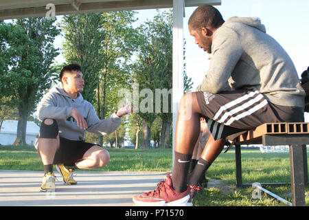 Sgt. 1st Class Joel Vallete, signal section chief of Headquarters Company, 1st Battalion, 8th Infantry Regiment, 3rd Armored Brigade Combat Team, 4th Infantry Division, gives some tips on how a boxer should feel in the ring on May 11, 2017 at Mihail Koglanicenau Air Base, Romania. With his combined experience and love for boxing, Vallete, an All Army Boxing coach, is able to give a constructive view of his trainees performances and allow them to recognize what they need to work on. Stock Photo