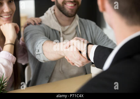 Satisfied couple handshaking realtor closing successful deal Stock Photo