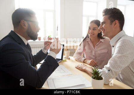 Male architect discussing house project with young couple Stock Photo