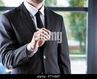 cropped view of businessman in suit singing something in office Stock Photo