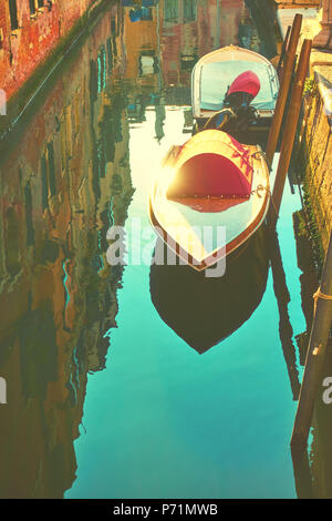 View of small venetian canal with moored boats in the early evening, Venice Stock Photo