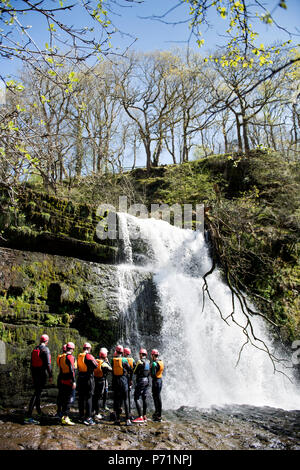 An instructor supervises a group gorge walking with Adventure Wales on the River Mellte near Pontneddfechan in the Brecon Beacons UK Stock Photo