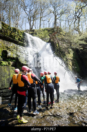 An instructor supervises a group gorge walking with Adventure Wales on the River Mellte near Pontneddfechan in the Brecon Beacons UK Stock Photo