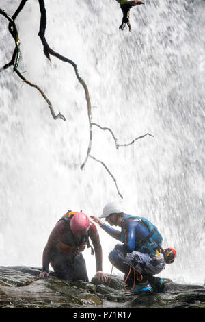 An instructor supervises a group gorge walking with Adventure Wales on the River Mellte near Pontneddfechan in the Brecon Beacons UK Stock Photo