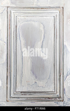 Old distressed wood door panel with peeling paint as framed background Stock Photo
