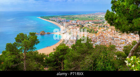 Coast, rock Sa Palomera and architecture of Spanish beach resort Blanes in summertime. Sunny panorama from height of mountain of castle San Juan. Cost Stock Photo