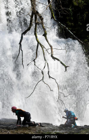 An instructor supervises a group gorge walking with Adventure Wales on the River Mellte near Pontneddfechan in the Brecon Beacons UK Stock Photo