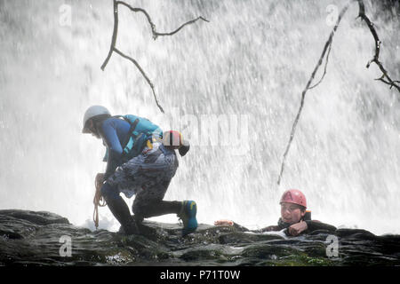 An instructor supervises a group gorge walking with Adventure Wales on the River Mellte near Pontneddfechan in the Brecon Beacons UK Stock Photo