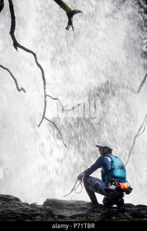 An instructor supervises a group gorge walking with Adventure Wales on the River Mellte near Pontneddfechan in the Brecon Beacons UK Stock Photo