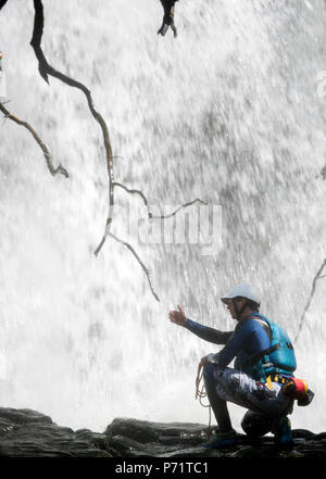 An instructor supervises a group gorge walking with Adventure Wales on the River Mellte near Pontneddfechan in the Brecon Beacons UK Stock Photo