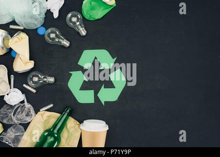 top view of various types of trash with recycle sign on black Stock Photo